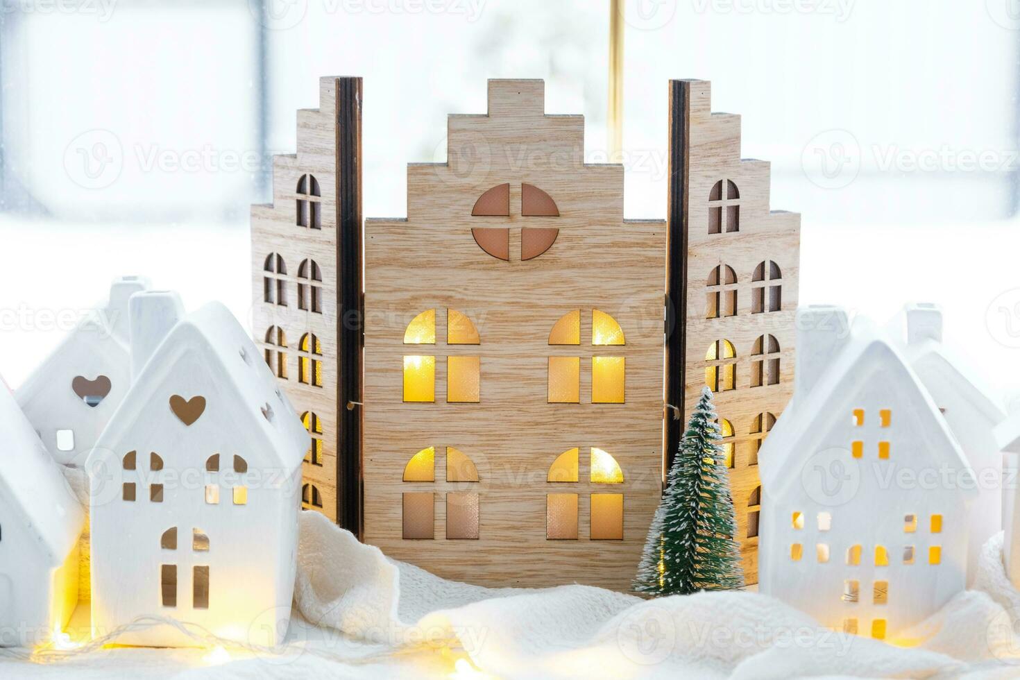 Cozy Christmas decor tiny house of small size on window sill with snow outside the window. Gift for New Year. Insurance, moving to new house, mortgage, rent and purchase real estate photo