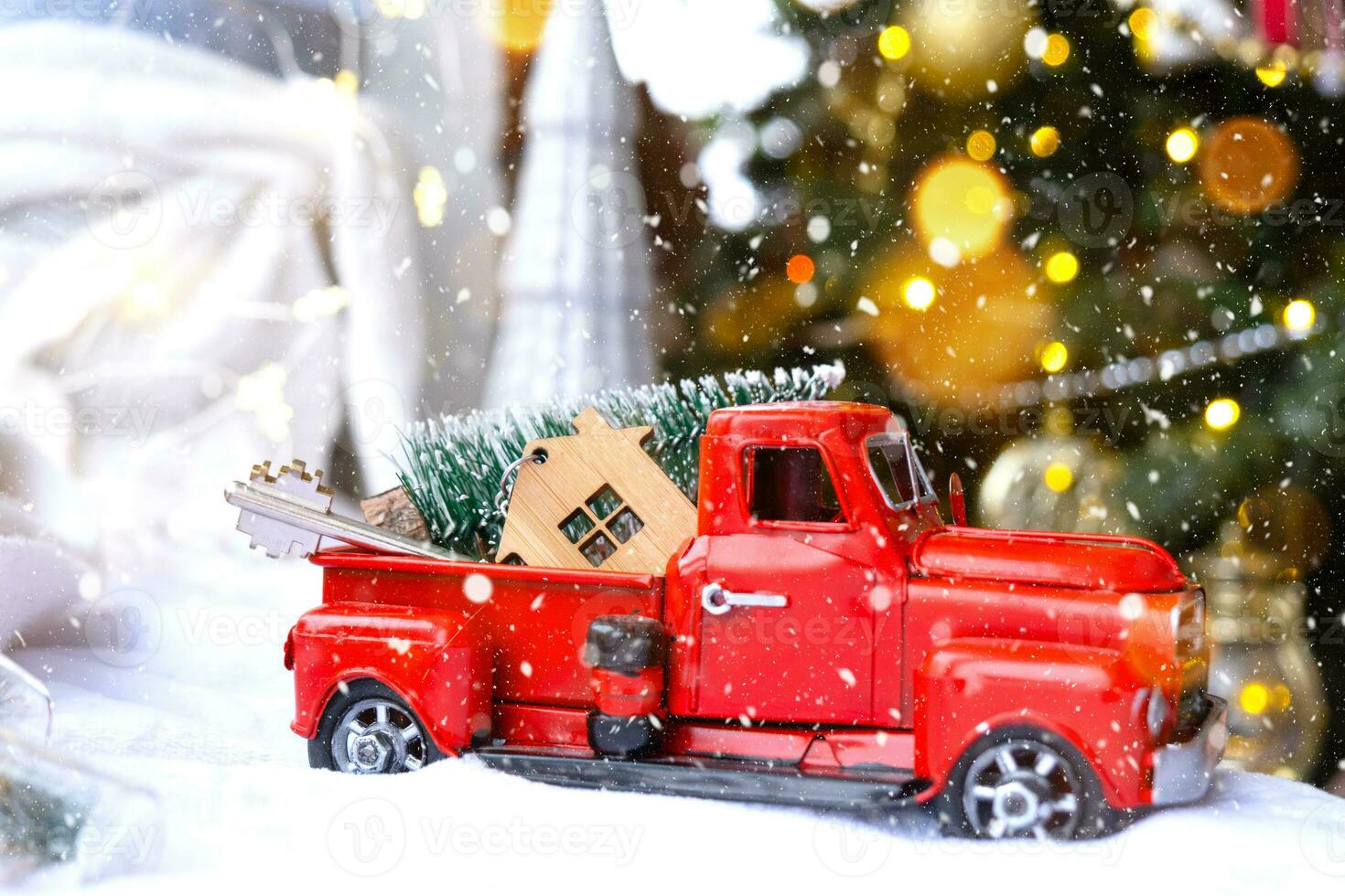 Red retro car with a Christmas tree decorates with the house key in the pickup truck for Christmas. Buying a home, moving, mortgage, loan, real estate, festive mood, New Year photo