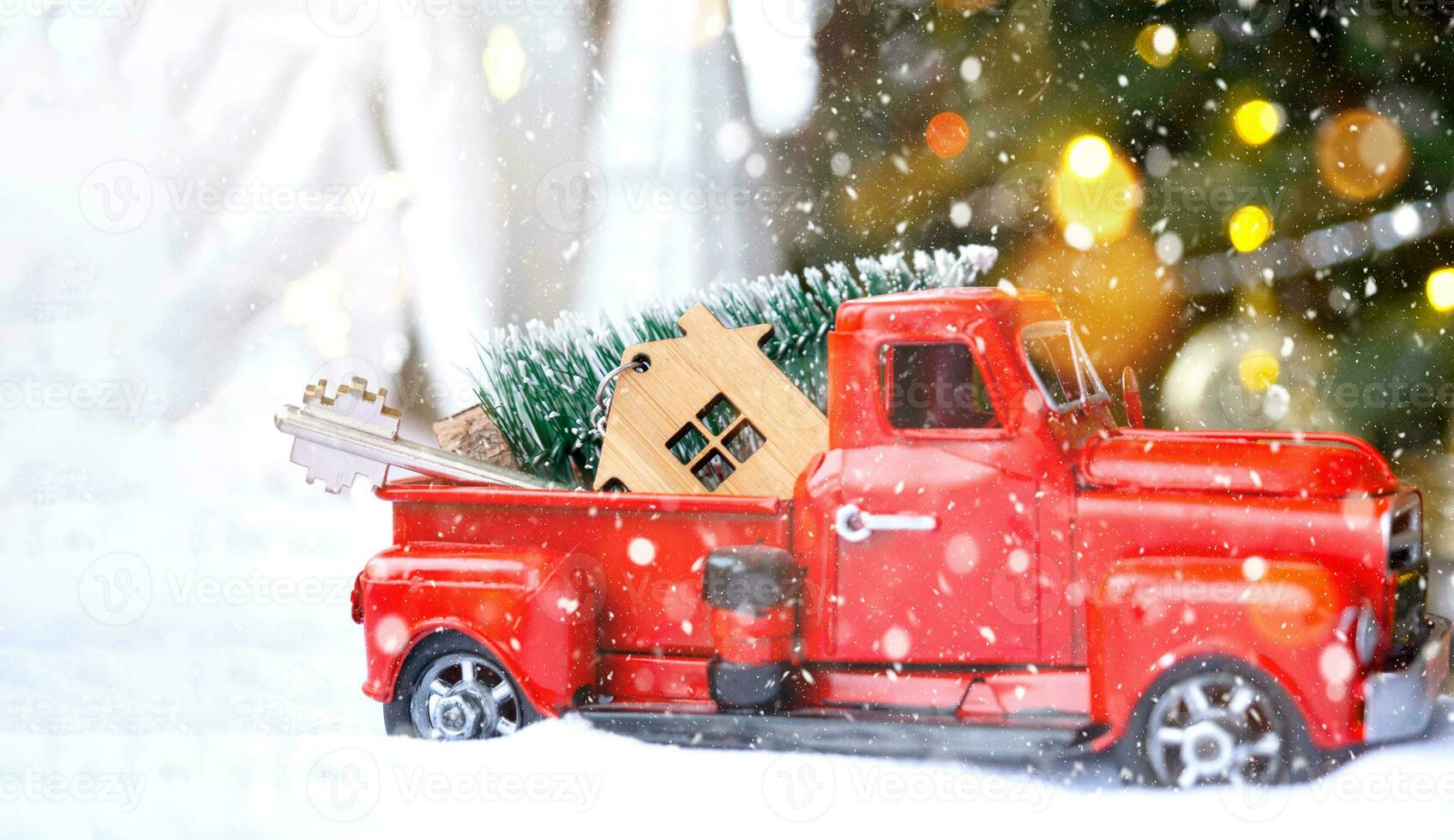 Red retro car with a Christmas tree decorates with the house key in the pickup truck for Christmas. Buying a home, moving, mortgage, loan, real estate, festive mood, New Year photo