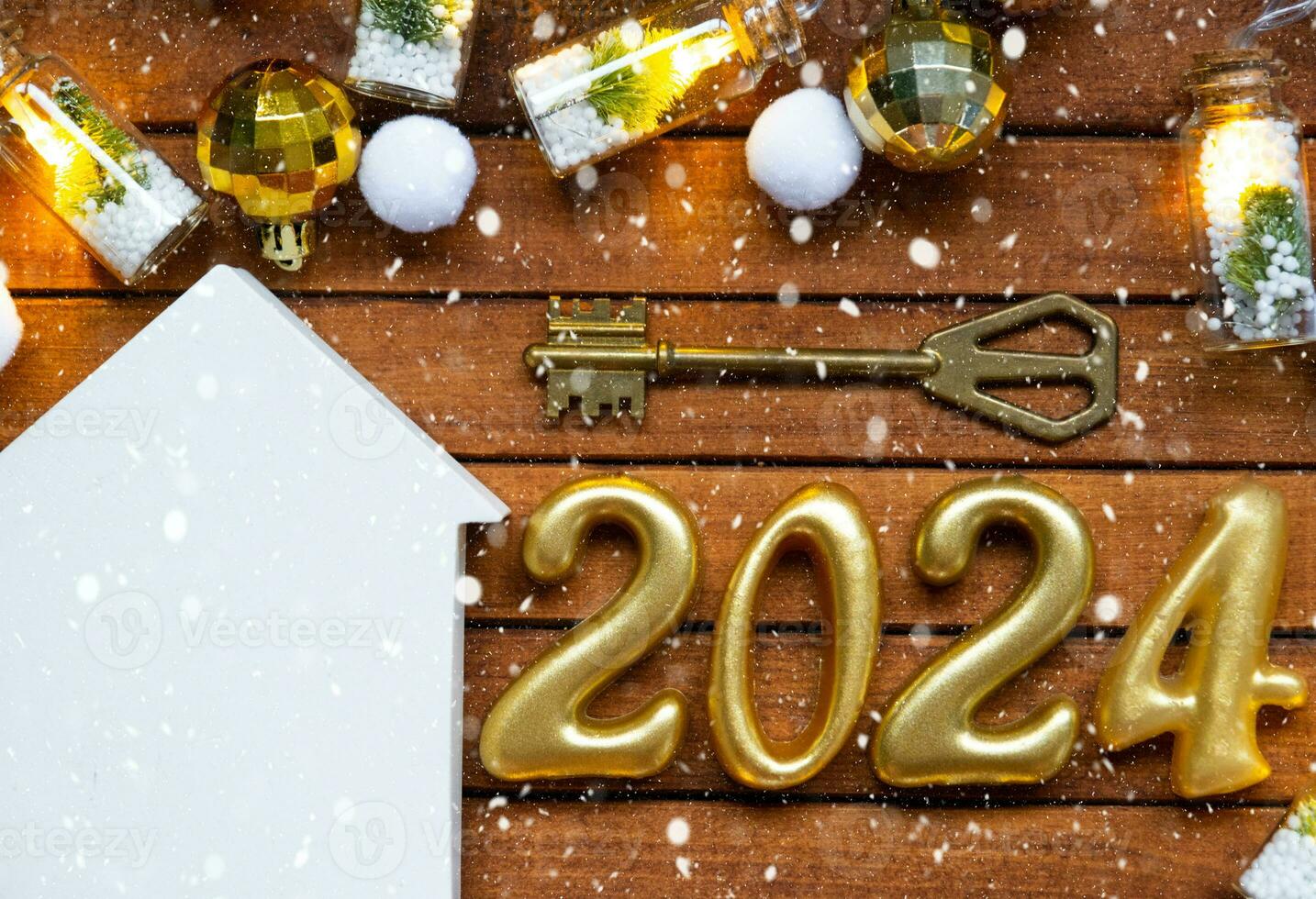 House key with tiny figure of home mock up on festive brown wooden background, lights of garlands. New Year 2024 wooden letters, greeting card. Purchase, construction, relocation, mortgage, insurance photo