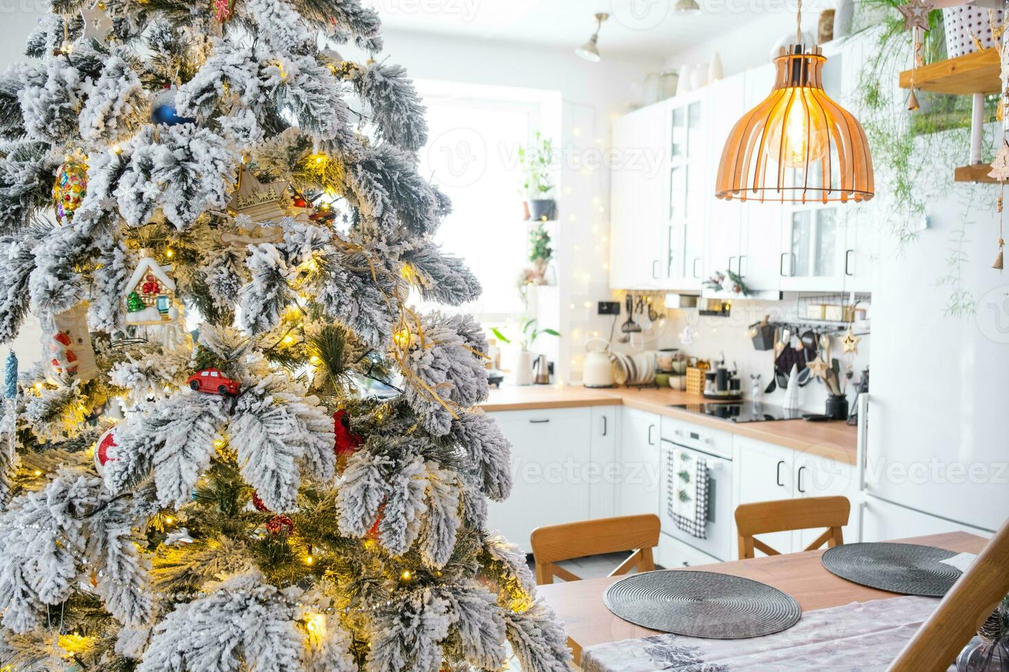 festivo Navidad decoración en blanco cocina, moderno rústico interior con un Nevado Navidad árbol y hada luces. nuevo año, Navidad ánimo, acogedor hogar. el general plan foto