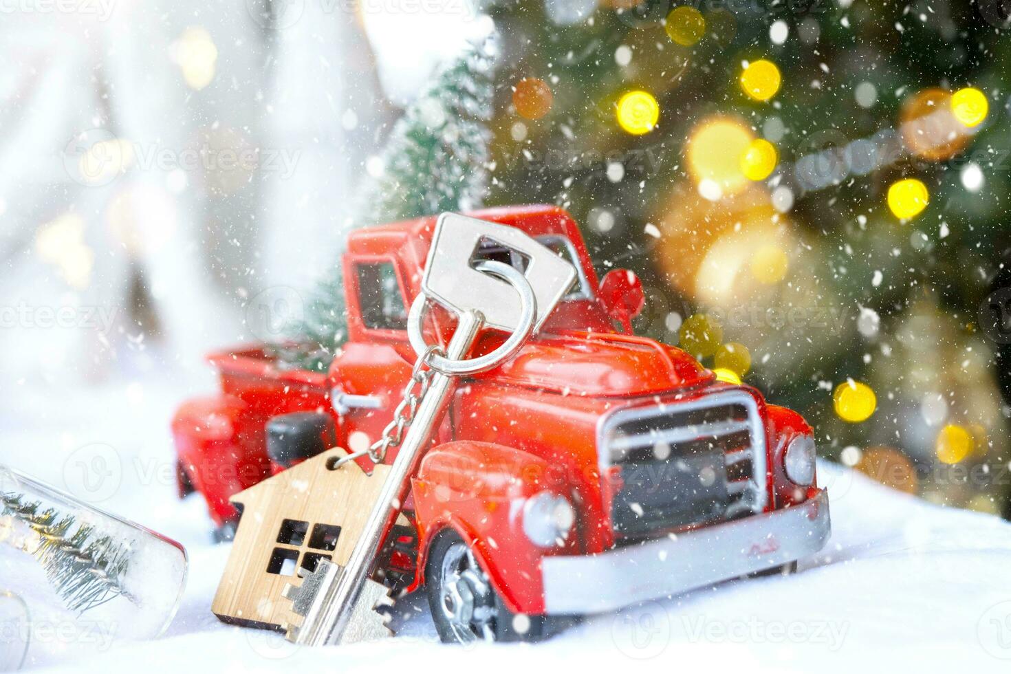 Red retro car with a Christmas tree decorates with the house key in the pickup truck for Christmas. Buying a home, moving, mortgage, loan, real estate, festive mood, New Year photo