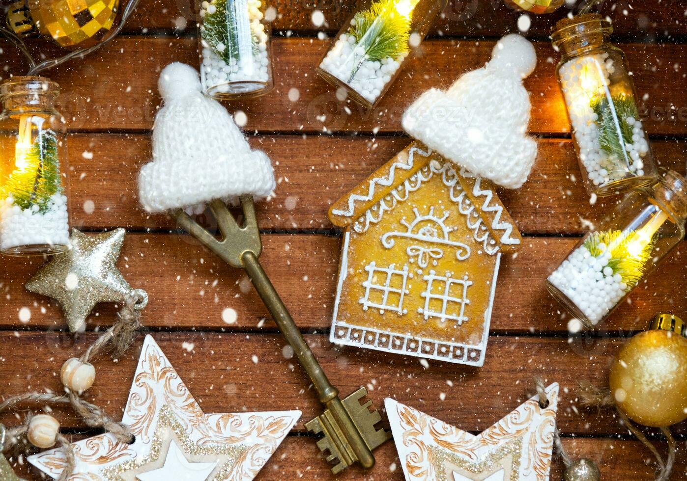 Key to house with a keychain tiny home on wooden background with Christmas decor layout. Gift for New Year, Christmas. Building, project, moving to new house, mortgage, rent and purchase real estate photo