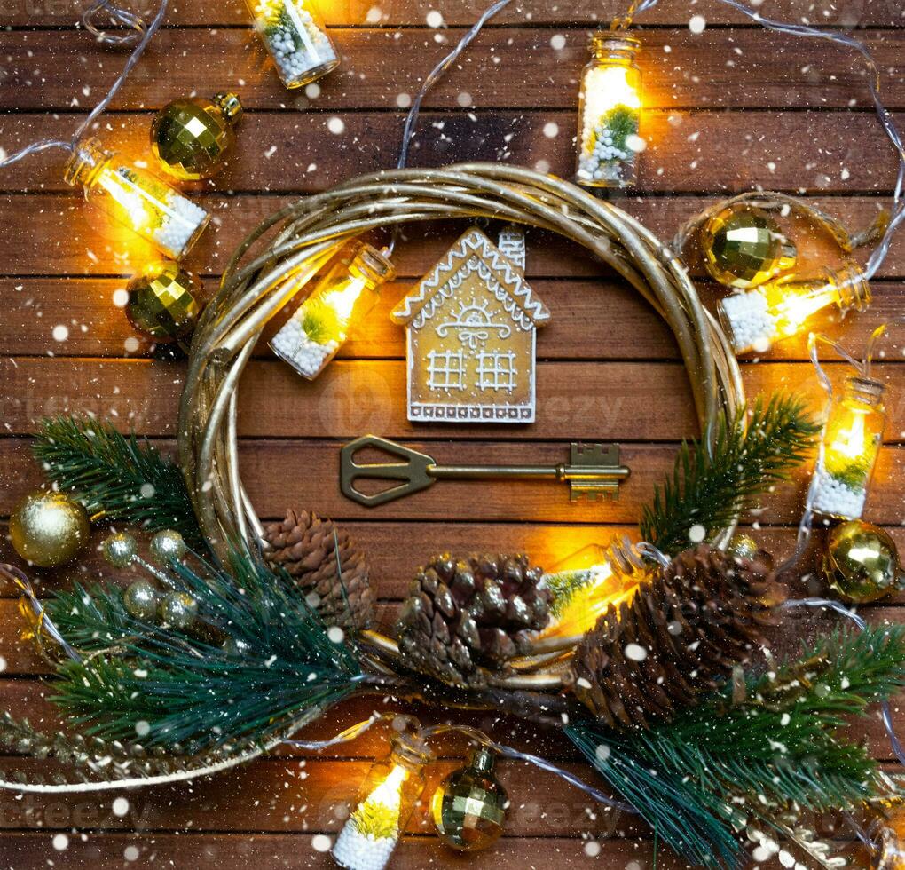 Key to house with a keychain tiny home on wooden background with Christmas decor layout. Gift for New Year, Christmas. Building, project, moving to new house, mortgage, rent and purchase real estate photo