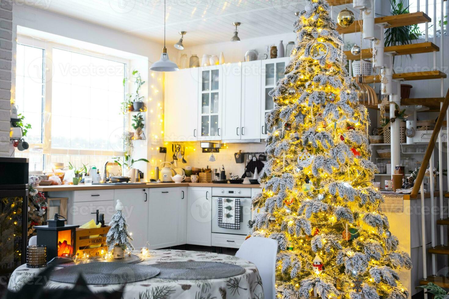 festivo Navidad decoración en blanco cocina, moderno pueblo interior con un Nevado Navidad árbol y hada luces. nuevo año, Navidad ánimo, acogedor hogar, metal modular escalera. el general plan foto