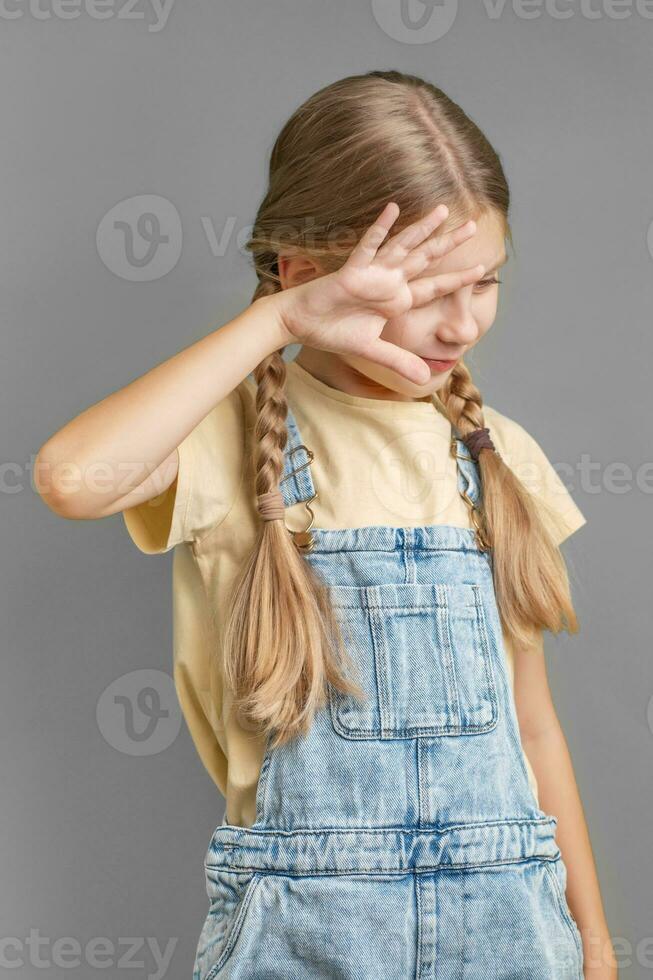 un pequeño niña muestra un firmar de protesta con su mano foto