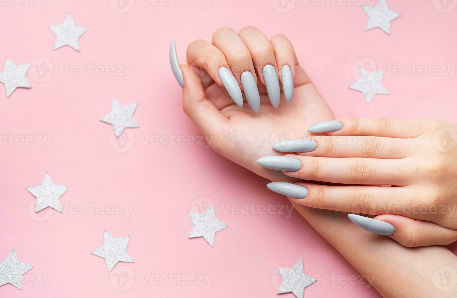 Hands with grey manicure on a pink background photo