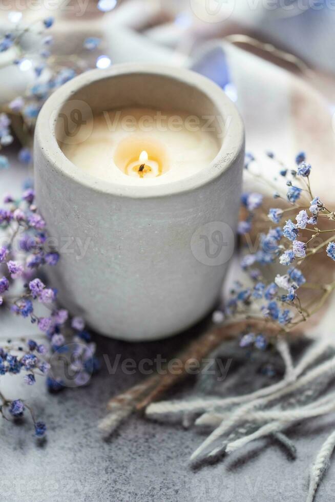 Candle and a branch of gypsophila flowers photo