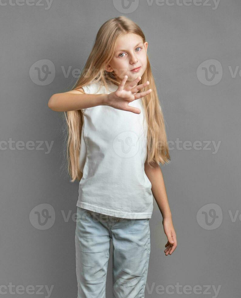 A little girl showing a sign of protest or refusal with her hand. photo