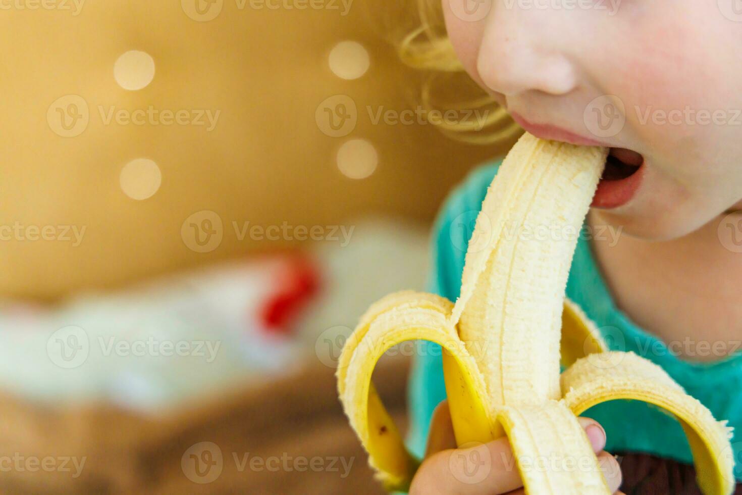 retrato de un pequeño niña comiendo un banana. el concepto de sano alimento. un Fresco rápido bocadillo foto