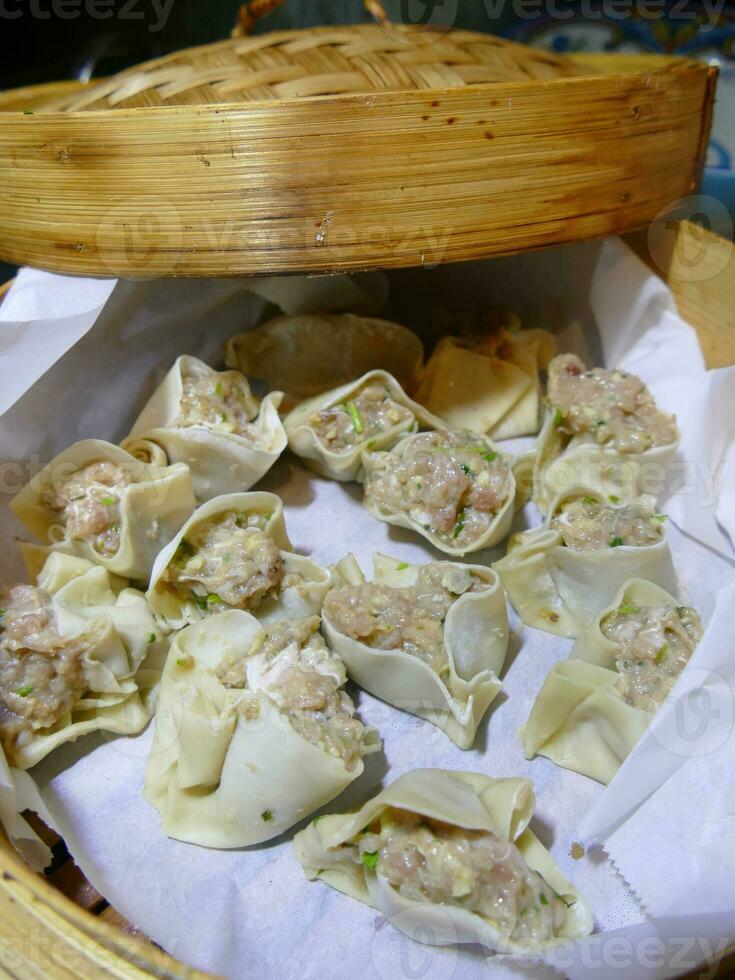 Steaming shumai dim sum in a bamboo steamer photo