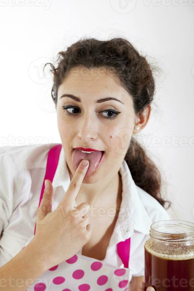 young pretty girl tasted honey from a finger photo