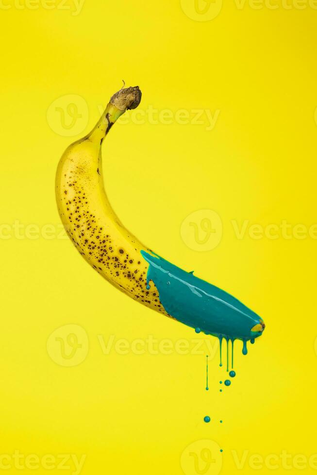 banana floating in the air with drops of green paint photo