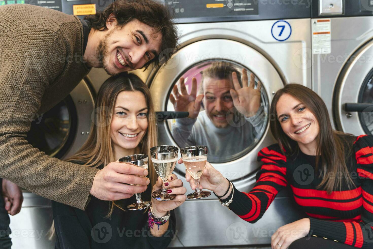 group of friends are toasting with white wine to a party in the laundry photo