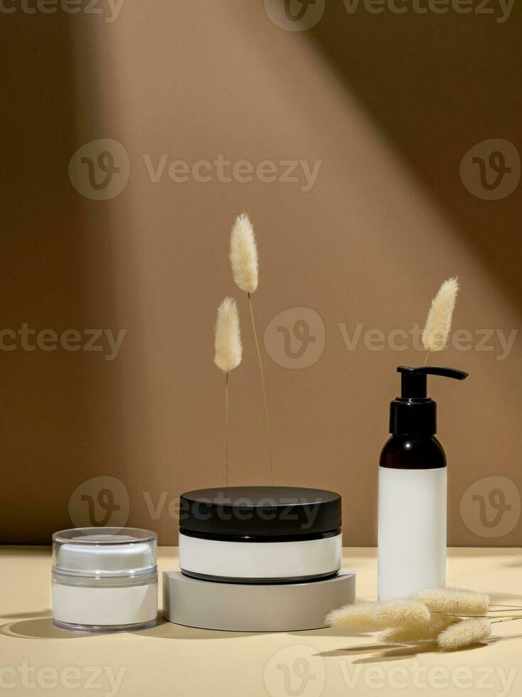 Mock up glass dropper bottles on a white podium on a beige background with hard shadows. Skin care products in trendy presentation photo