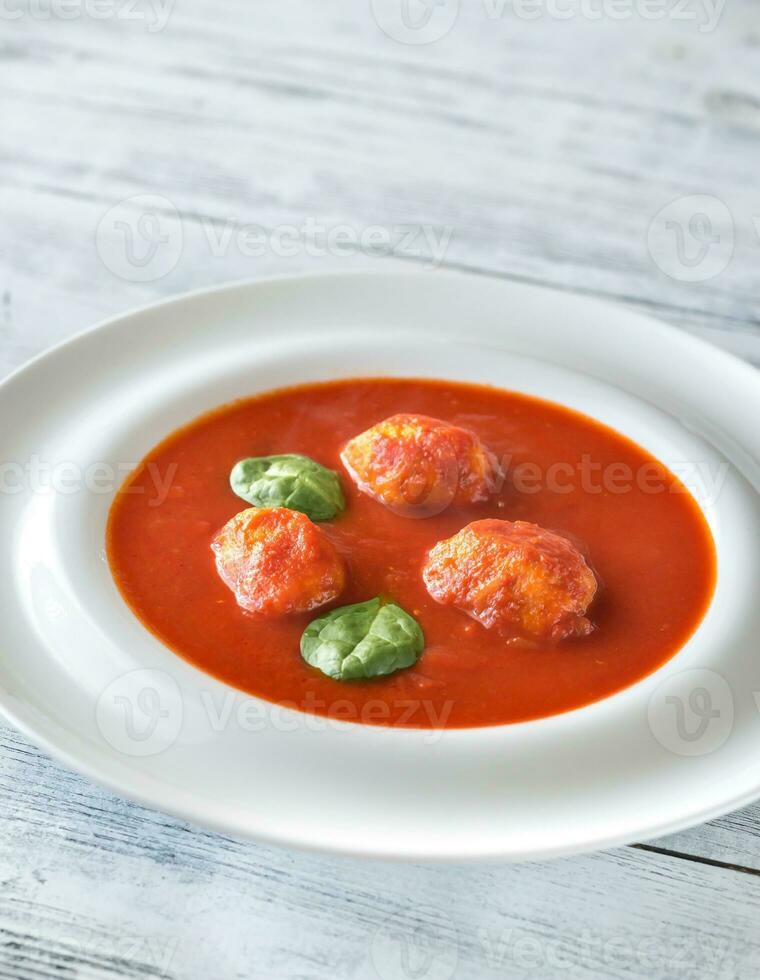 Portion of tomato soup with meatballs photo