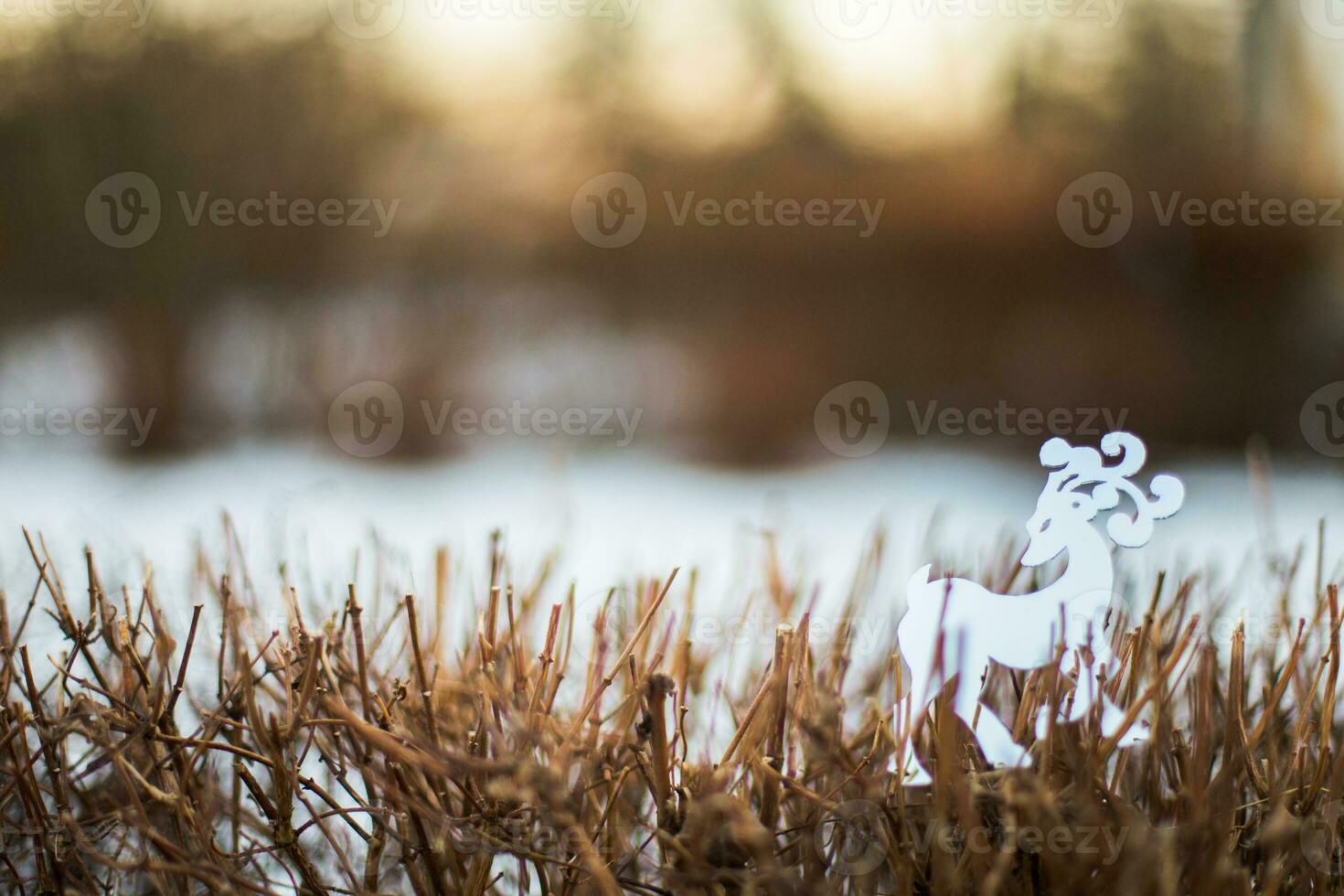 blanco reno figurilla en pie en el nieve en invierno bosque foto