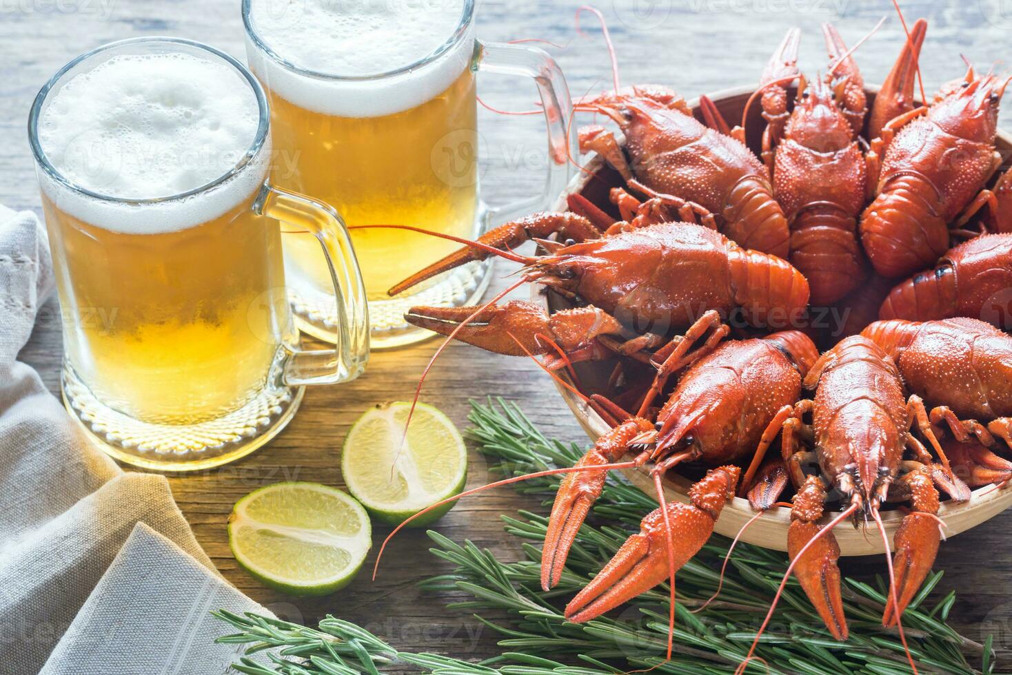 cuenco de hervido cangrejo de río con dos tazas de cerveza foto