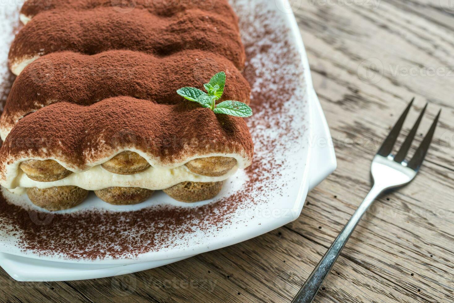 Tiramisu on the plate on the wooden background photo