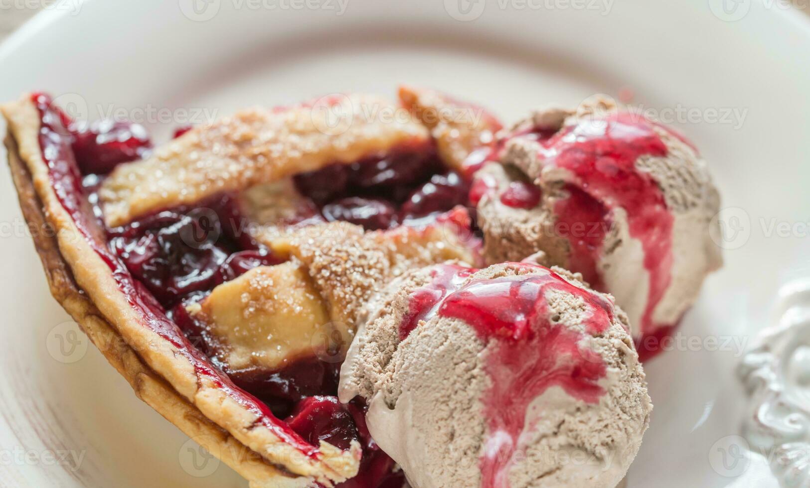 Slice of cherry pie with balls of chocolate ice cream photo