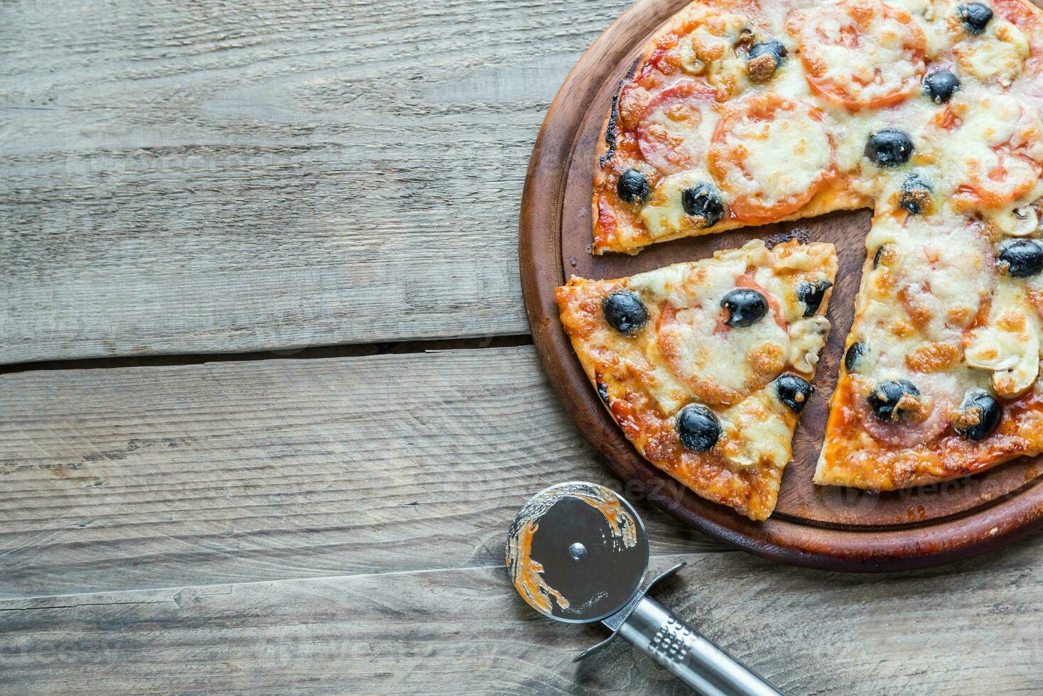 Cooked pizza on the wooden board photo