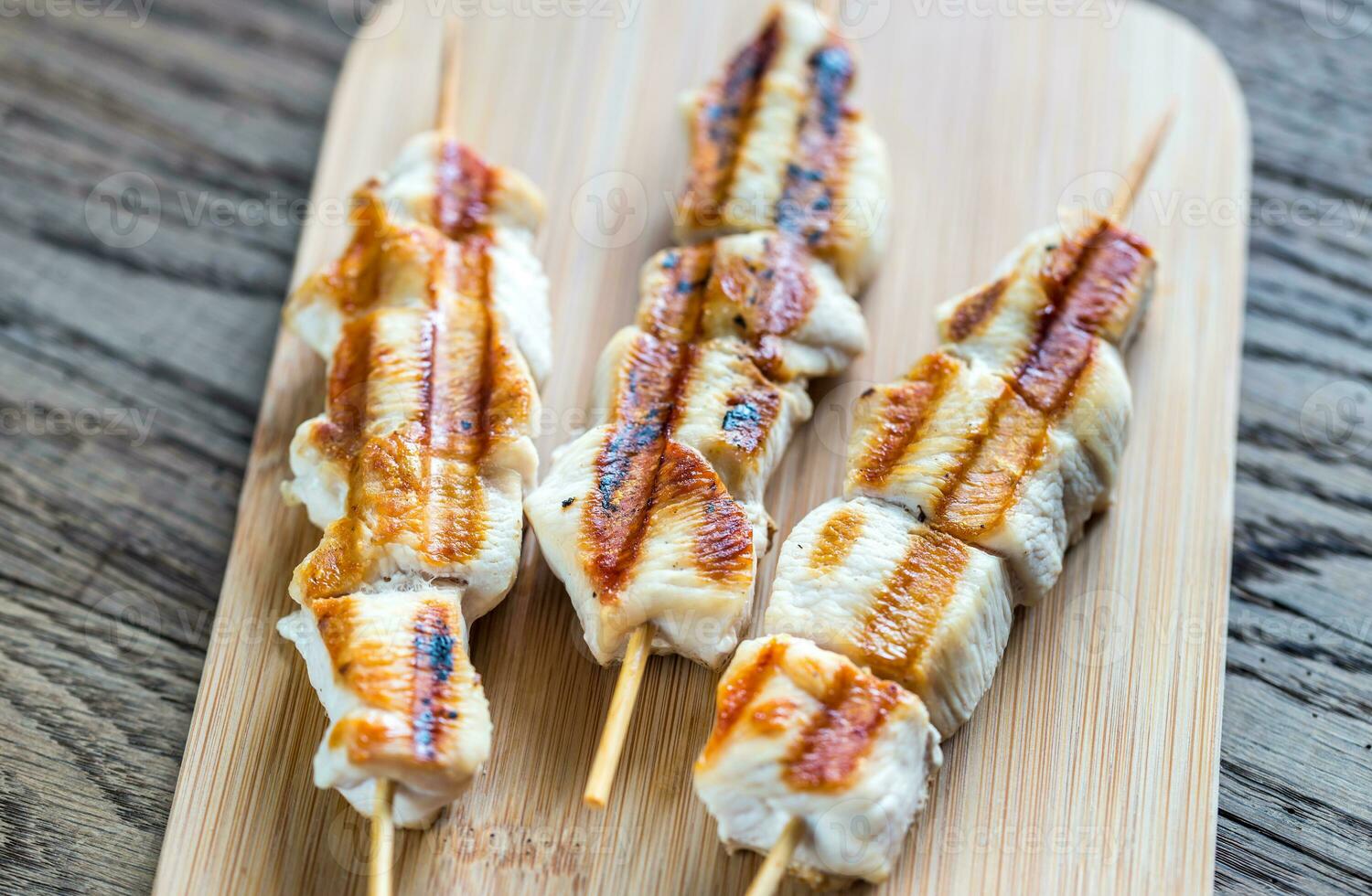 Grilled chicken skewers on the wooden board photo