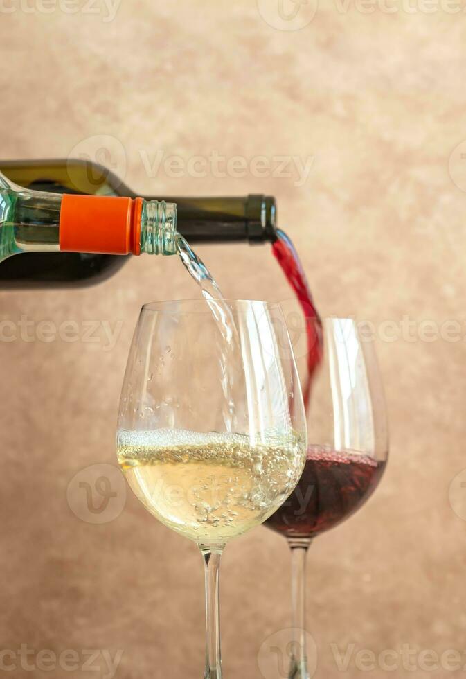 White and red wine pouring into glasses photo