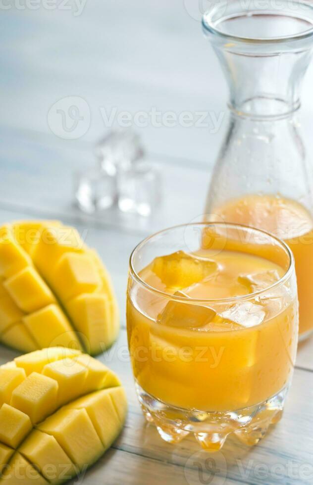 mango jugo en el de madera mesa foto