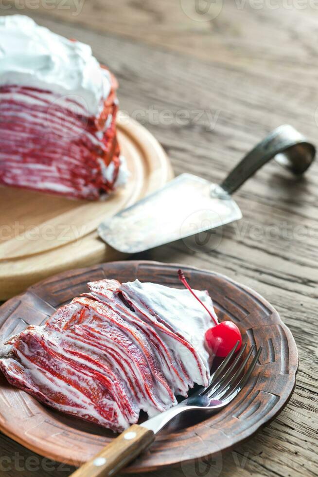 Portion of red velvet crepe cake on the wooden table photo