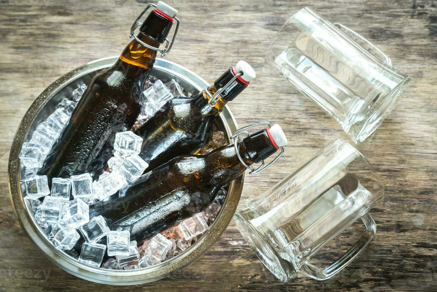 botellas de cerveza en hielo cubitos foto