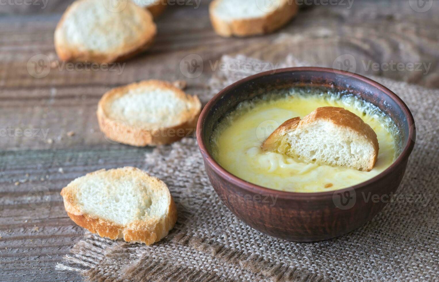 Bowl of cheese dip with toasts photo
