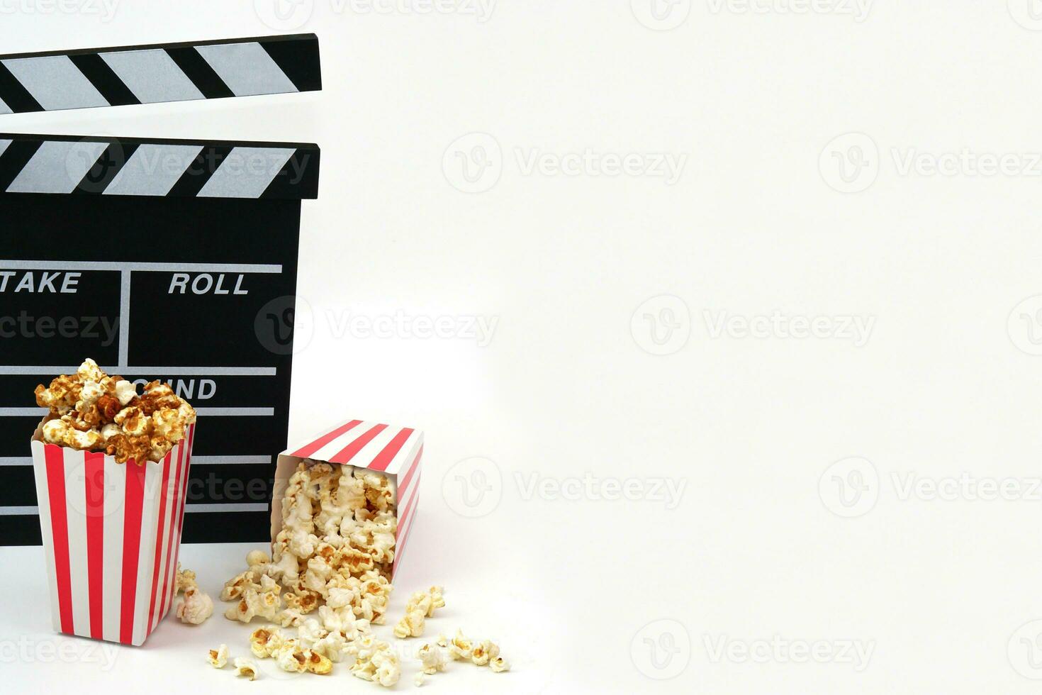 Clapperboard or movie slate black color with popcorn on white background. Cinema industry, video production and film concept. photo