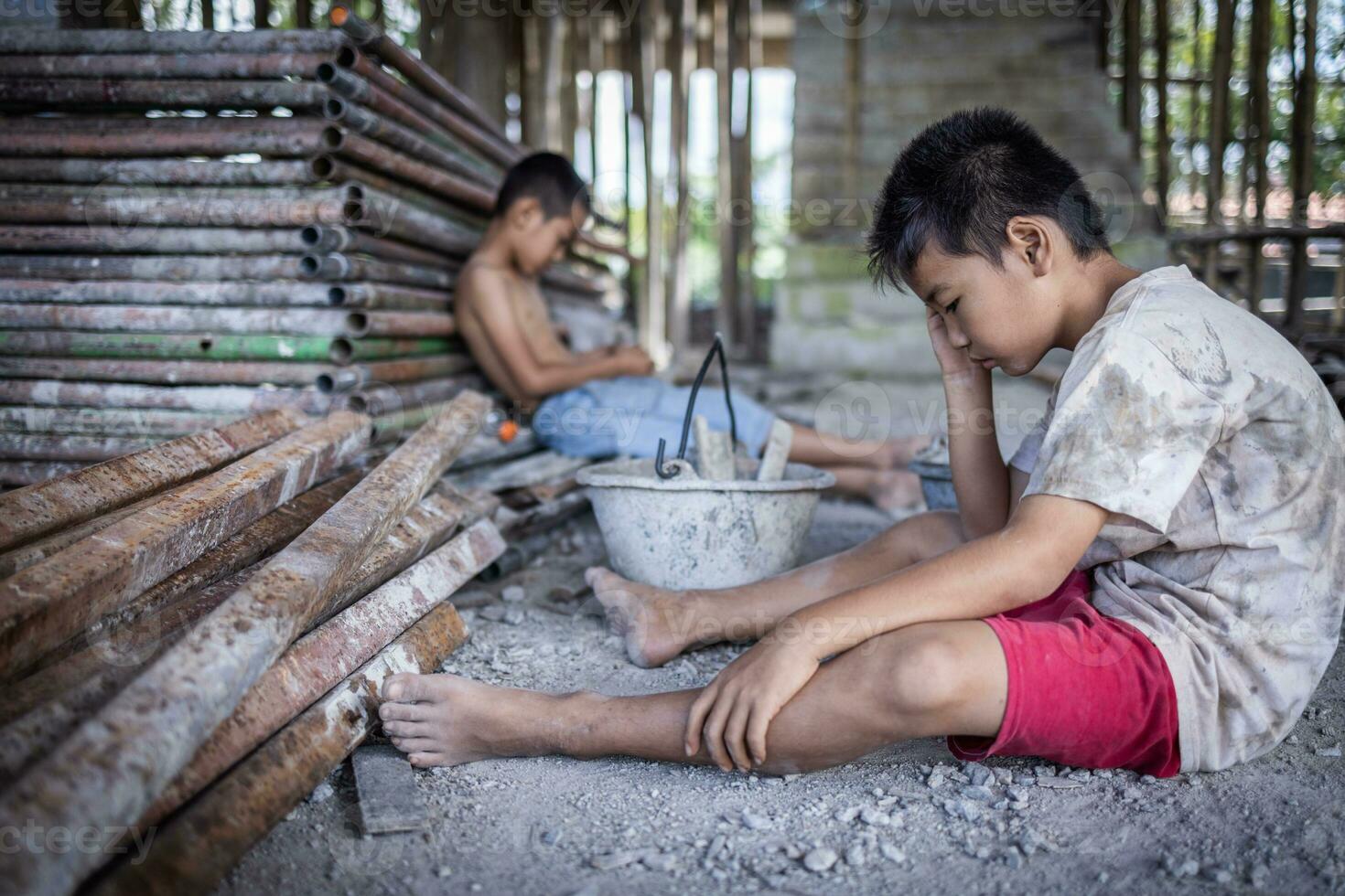 Concept of child labor, poor children being victims of construction labor, human trafficking, child abuse. photo