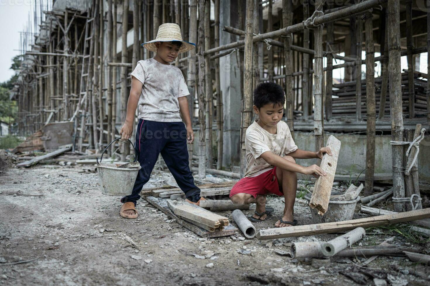 Concept of child labor, poor children being victims of construction labor, human trafficking, child abuse. photo