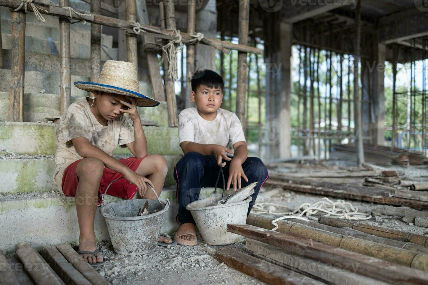 Concept of child labor, poor children being victims of construction labor, human trafficking, child abuse. photo