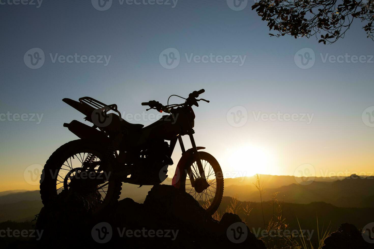 motocross bike against beautiful lights, silhouette of a  motocross motorcycle On top of rock high mountain at beautiful sunset, enduro motorcycle travel concept. photo