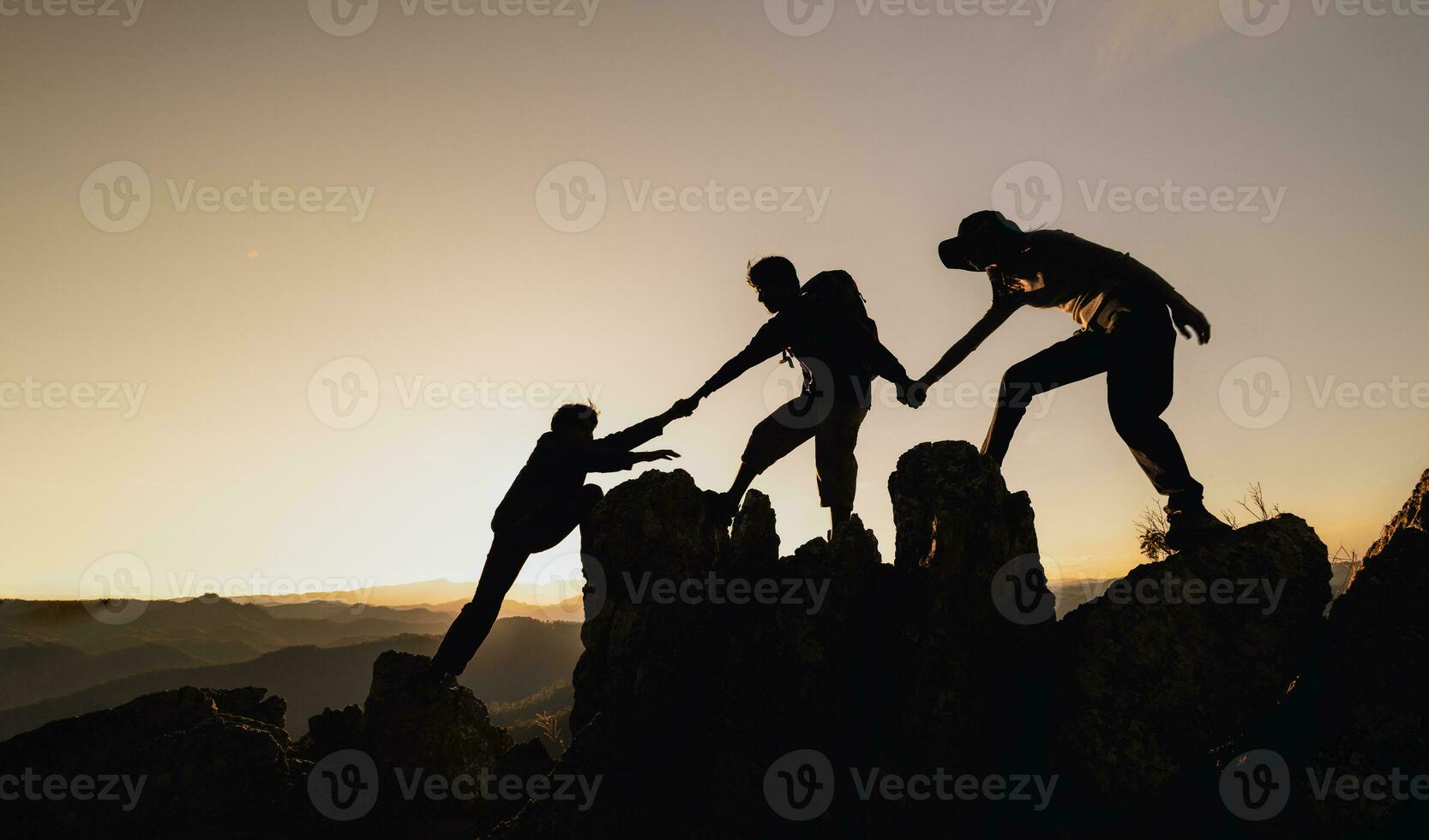 silhouette male and female hikers climbing up mountain cliff. helps and team work concept. Independent hiking travel, success. photo