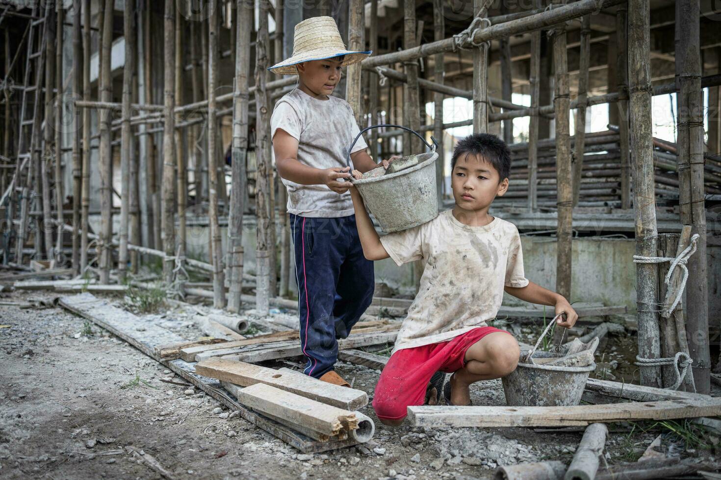 Concept of child labor, poor children being victims of construction labor, human trafficking, child abuse. photo