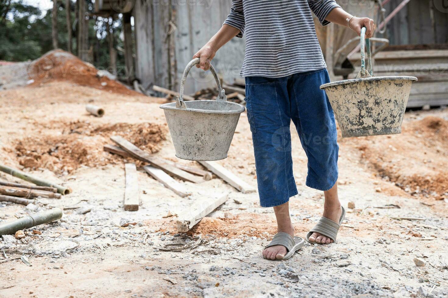 Children forced to work hard at construction site, child labor concept, poor children victims of human trafficking process, poverty, child abuse. photo