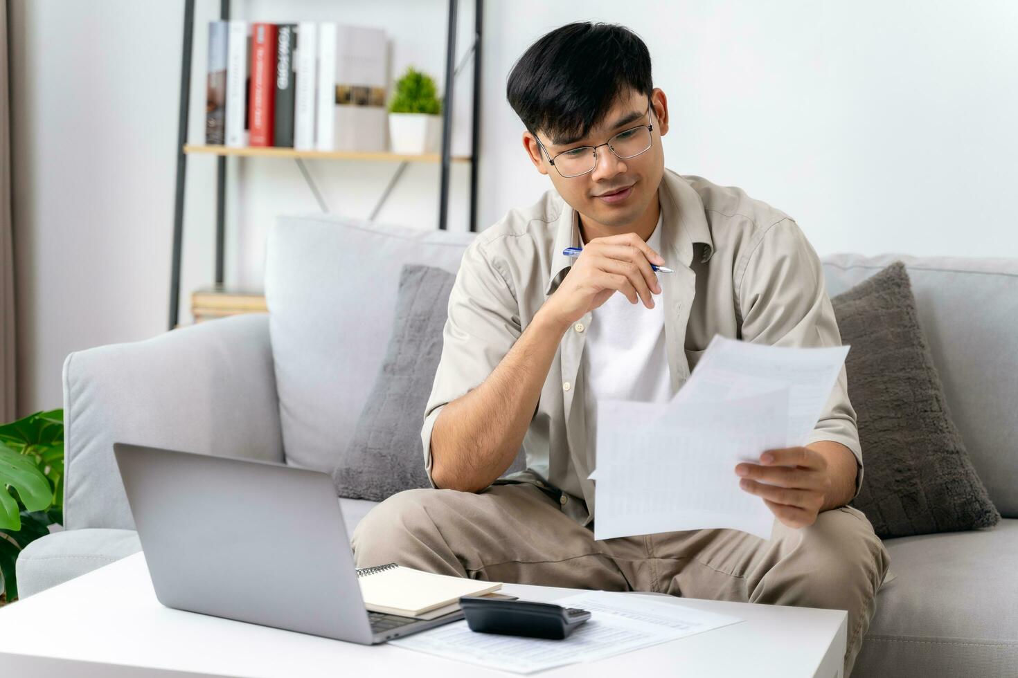 Man is calculating annual tax with calculator and filling form of Individual Income Tax Return. Season to pay Tax and Budget planning concept. photo