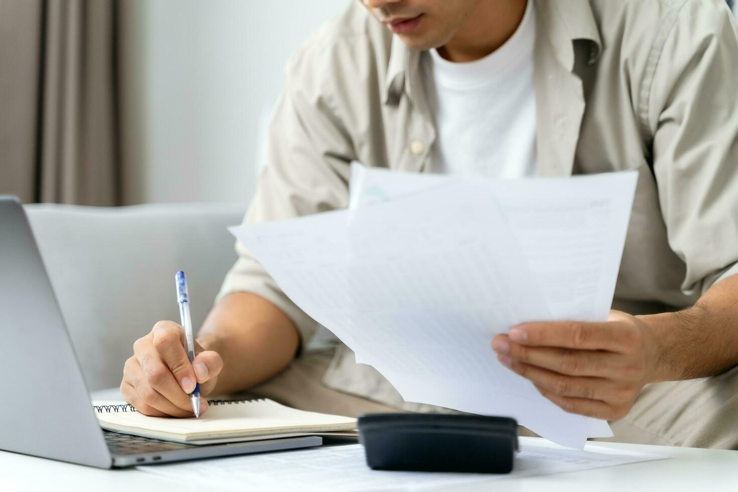 el hombre está calculando el impuesto anual con calculadora y llenando el formulario de declaración de impuestos sobre la renta individual. temporada para pagar impuestos y concepto de planificación presupuestaria. foto