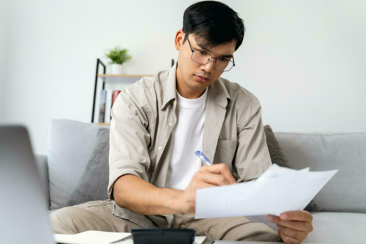 el hombre está calculando el impuesto anual con calculadora y llenando el formulario de declaración de impuestos sobre la renta individual. temporada para pagar impuestos y concepto de planificación presupuestaria. foto