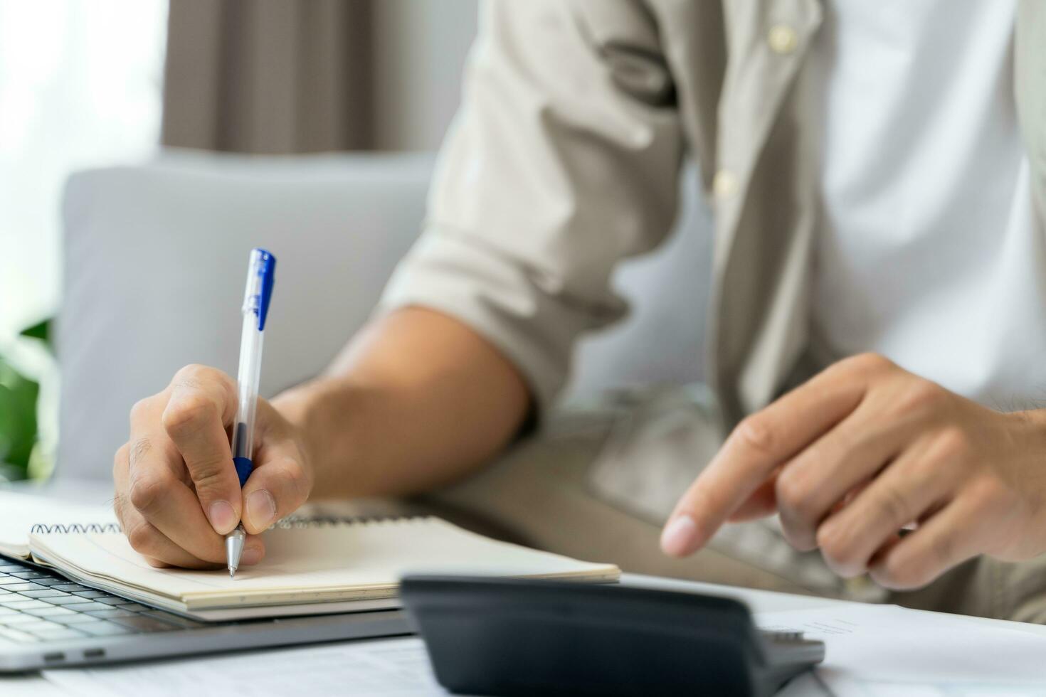 el hombre está calculando el impuesto anual con calculadora y llenando el formulario de declaración de impuestos sobre la renta individual. temporada para pagar impuestos y concepto de planificación presupuestaria. foto