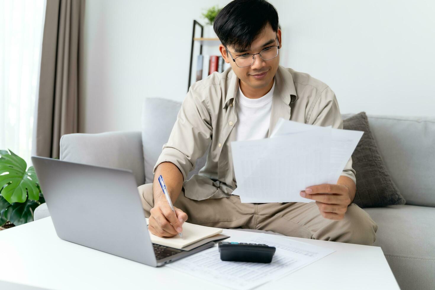 Man is calculating annual tax with calculator and filling form of Individual Income Tax Return. Season to pay Tax and Budget planning concept. photo