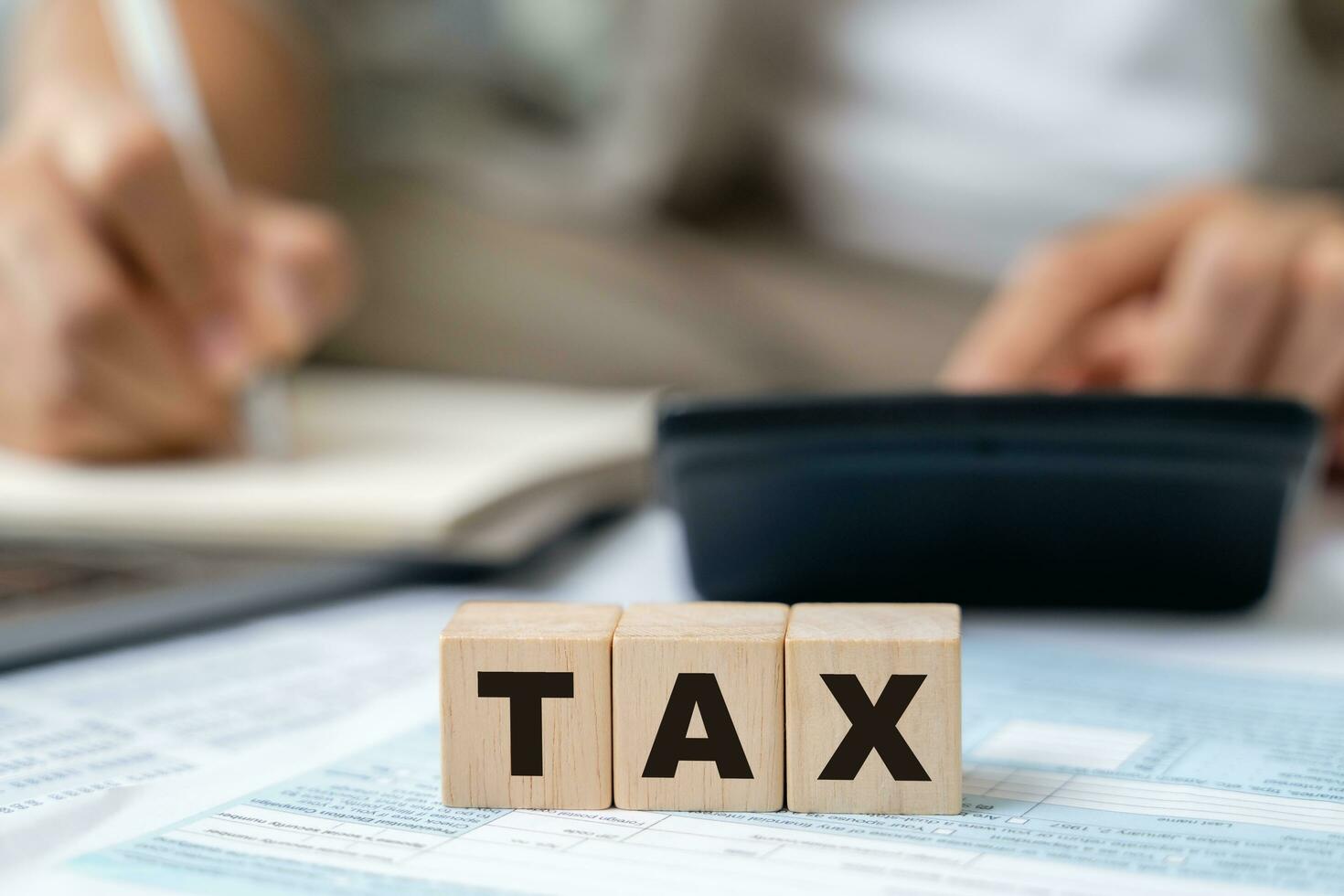 Man is calculating annual tax, monthly expenses with calculator and filling form of Individual Income Tax Return. Season to pay Tax and Budget planning concept. photo