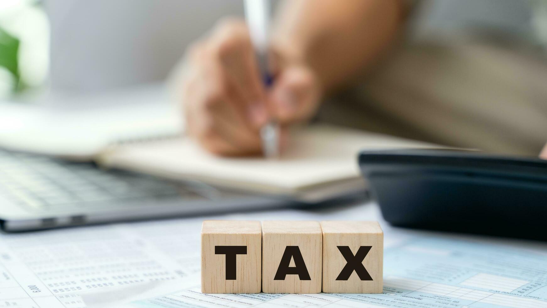 Man is calculating annual tax, monthly expenses with calculator and filling form of Individual Income Tax Return. Season to pay Tax and Budget planning concept. photo