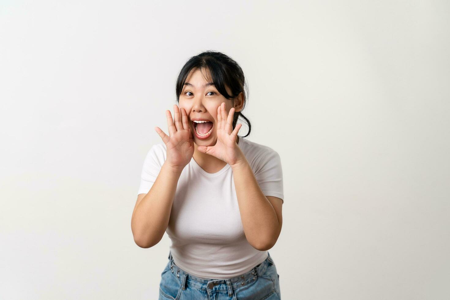el retrato de hermosa joven asiático mujer es levantamiento su mano arriba a su boca para susurro o gritar fuera gesto. foto