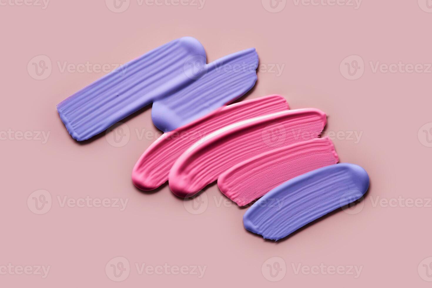 Pink and violet eye shadows Samples on pink background. Swatches of cream makeup strokes photo