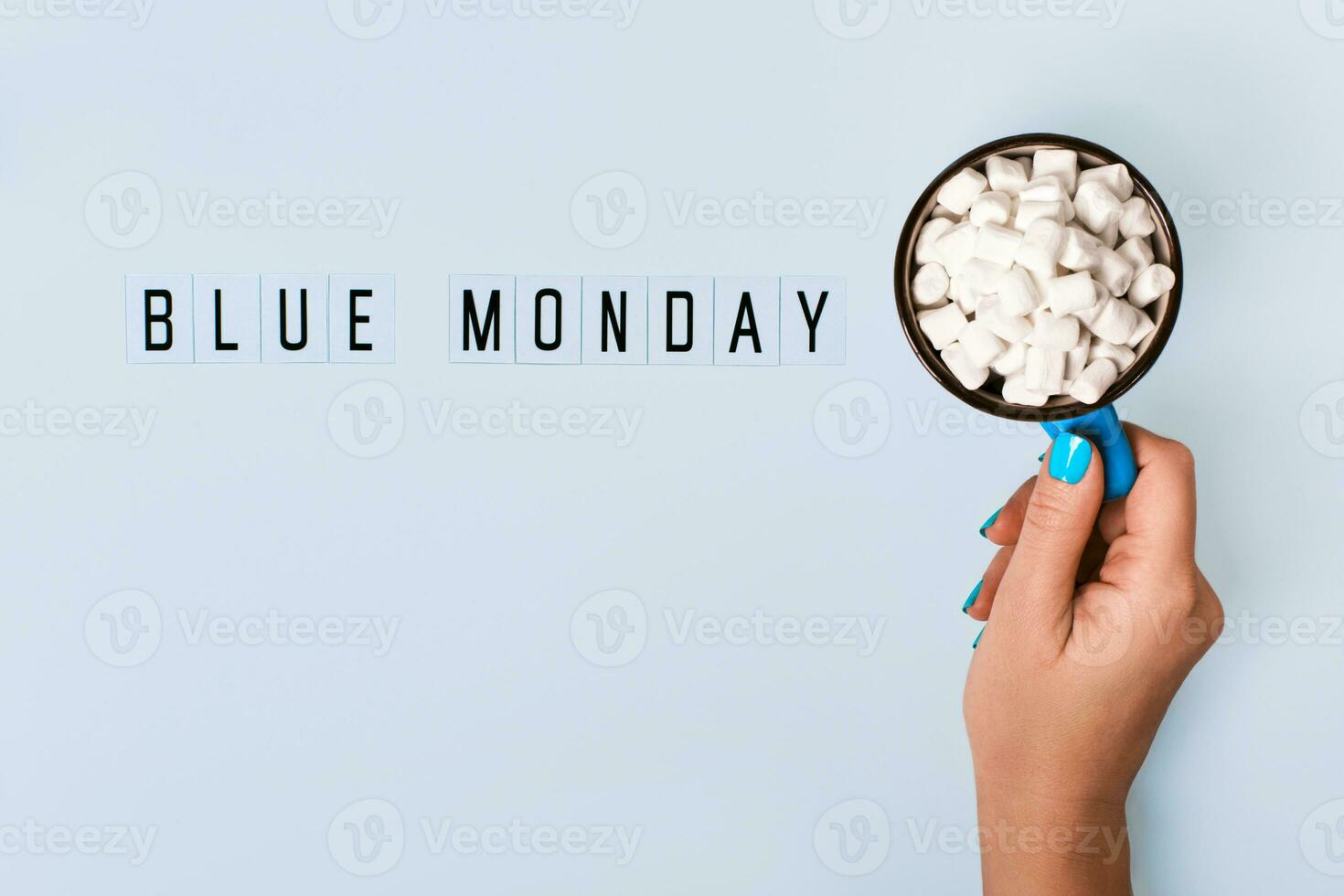 Blue monday text and female hand holds blue mug with cocoa on blue background. Blue monday concept photo