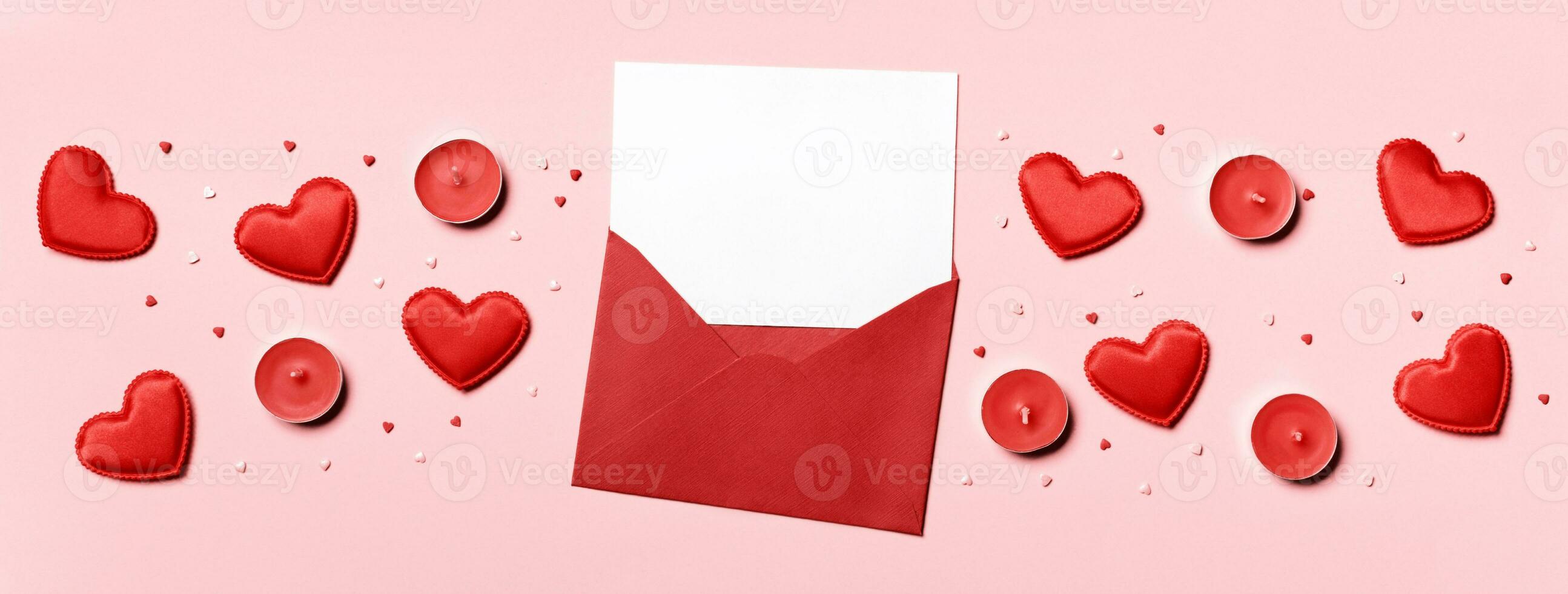 Romantic concept. Valentines day background. Red envelope with blank letter and hearts on pink banner photo